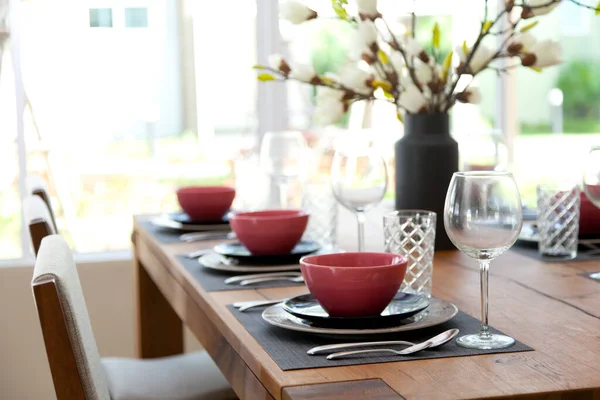 Modern yemek odasındaki yemek masasının üzerindeki cam ve tabağı kapatın. İç tasarım kavramı.