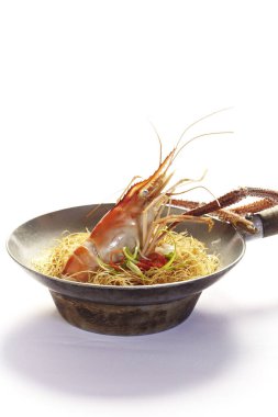 Beyaz arka planda kil çömlekte vermicelli güveçte karidesler.