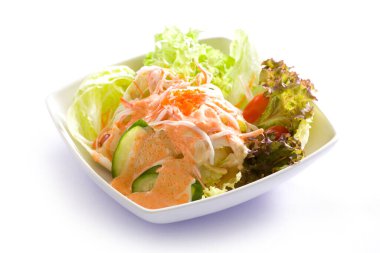 Japon salatası ve taze çiğ somon. Taze sebzeli Asya salatası, beyaz arka planda ince dilimlenmiş çiğ et somonu..