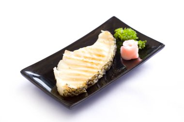 Beyaz arka planda siyah tabakta tuzlu ızgara somon bifteği..