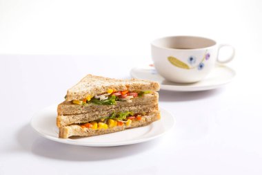 Beyaz arka planda bir fincan kahveli ızgara sandviç..