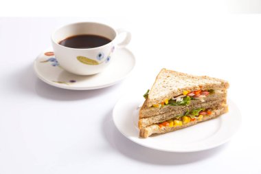 Beyaz arka planda bir fincan kahveli ızgara sandviç..