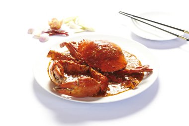 Beyaz arkaplanda köri tozu içinde kızarmış yengeç.