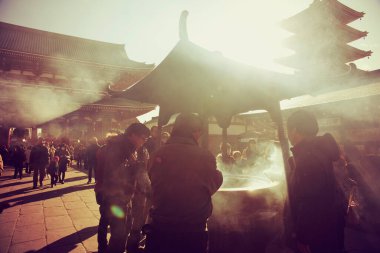 Japonlar tütsü dumanını Sensoji Tapınağı, Tokyo 'da arınma ritüeli olarak üstlerine sallıyorlar..