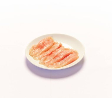 Beyaz arka planda dilimlenmiş tavuk göğsü filetosu.. 