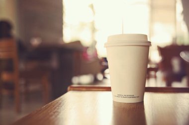 Kahve dükkanının tezgahında kağıt bir kahve fincanı var..