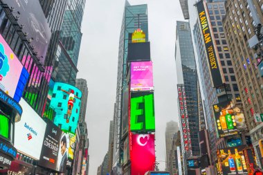 NEW YORK CITY, NY - 26 Nisan 2018: Times Meydanında yürüyen turist kalabalığı 26 Nisan 2018 'de New York City' de duvarda LED levhalarıyla.