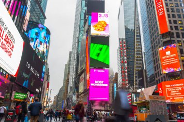 NEW YORK CITY, NY - 26 Nisan 2018: Times Meydanında yürüyen turist kalabalığı 26 Nisan 2018 'de New York City' de duvarda LED levhalarıyla.