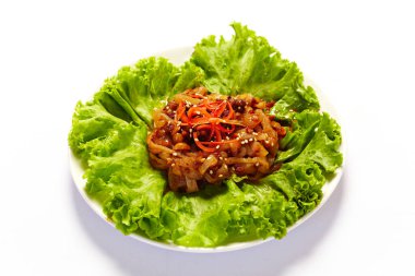 Beyaz arka planda bir tabakta korunmuş denizanası. Çin aperatifleri ana yemekten önce.