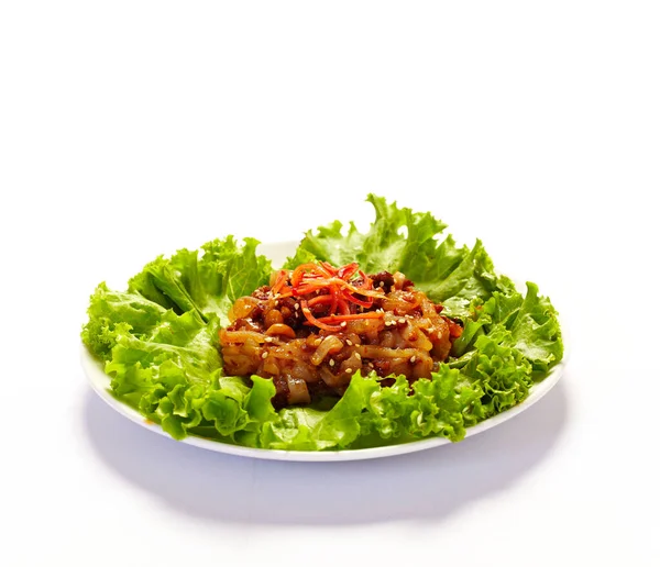 Beyaz arka planda bir tabakta korunmuş denizanası. Çin aperatifleri ana yemekten önce.