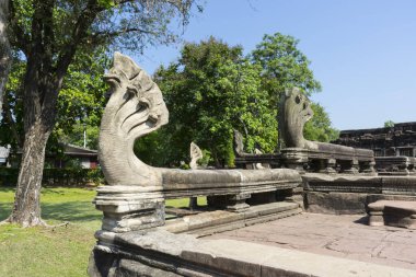 Nakhon Ratchasima, Tayland 'daki Phimai Tarih Parkının girişinde canlı mavi gökyüzü altında Yedi Başlı Naga Heykelleri.
