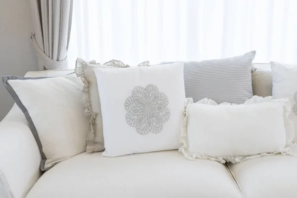 Kırsal ve kır tarzı oturma odasında beyaz koltukta beyaz rahat yastık..