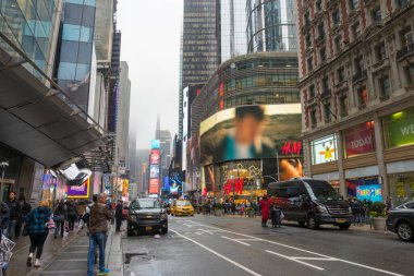 NEW YORK CITY, NY - 26 Nisan 2018: Times Meydanında yürüyen turist kalabalığı 26 Nisan 2018 'de New York City' de duvarda LED levhalarıyla.