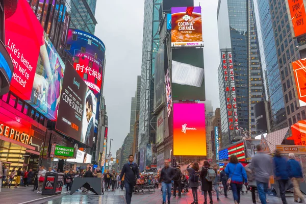 NEW YORK CITY, NY - 26 Nisan 2018: Times Meydanında yürüyen turist kalabalığı 26 Nisan 2018 'de New York City' de duvarda LED levhalarıyla.