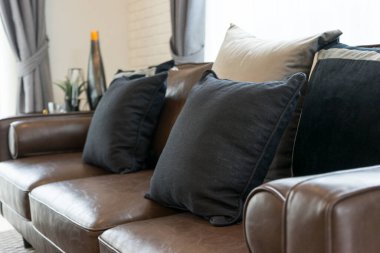 Kahverengi deri kanepe ve yastık modern iç tasarım ve ev dekoruyla oturma odasında..