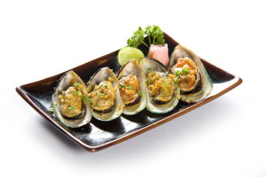 Beyaz arka planda bir tabakta sarımsaklı midye..