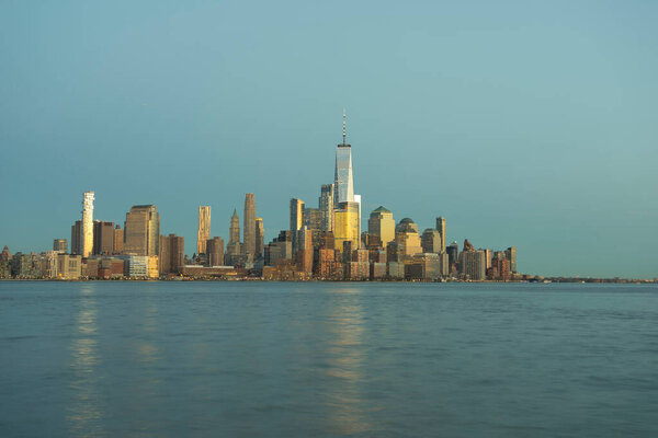 New York City, Manhattan skyline at sunset over Hudson River viewed from New Jersey.
