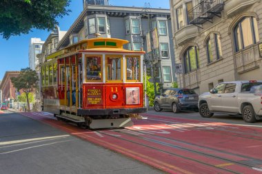 Yolcular San Francisco, California 'da bir teleferiğe binmenin keyfini çıkarıyorlar..