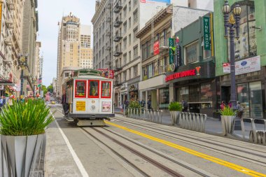 Yolcular San Francisco, California 'da bir teleferiğe binmenin keyfini çıkarıyorlar..