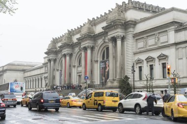 New York 'ta yağmurlu bir günde Metropolitan Müzesi' nin önünde yürüyen bir sürü turist.