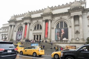 New York 'ta yağmurlu bir günde Metropolitan Müzesi' nin önünde yürüyen bir sürü turist.