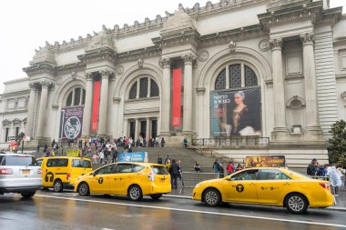 New York 'ta yağmurlu bir günde Metropolitan Müzesi' nin önünde yürüyen bir sürü turist.