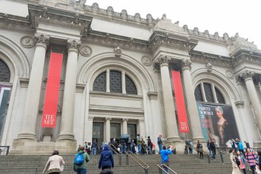 New York 'ta yağmurlu bir günde Metropolitan Müzesi' nin önünde yürüyen bir sürü turist.