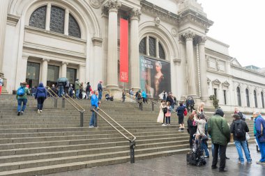 New York 'ta yağmurlu bir günde Metropolitan Müzesi' nin önünde yürüyen bir sürü turist.