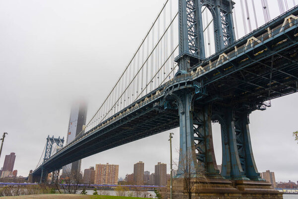 Manhattan Bridge with cloud over East River in Lower Manhattan in New York City.
