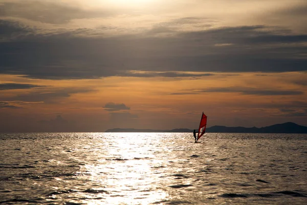 美丽的夕阳西下 一个在海湾波浪上冲浪的男人的轮廓 — 图库照片