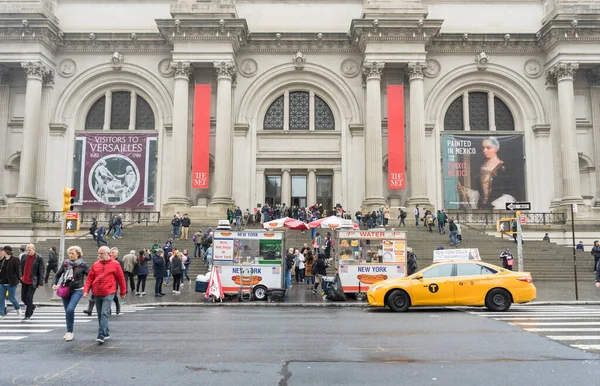 New York 'ta yağmurlu bir günde Metropolitan Müzesi' nin önünde yürüyen bir sürü turist.