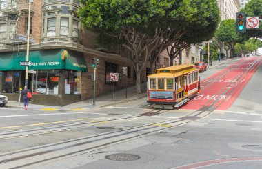Yolcular San Francisco, California 'da bir teleferiğe binmenin keyfini çıkarıyorlar..