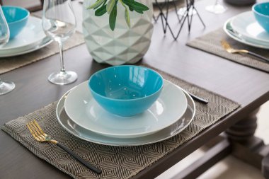 Modern evdeki ahşap masa üzerinde mavi ve beyaz tabak..