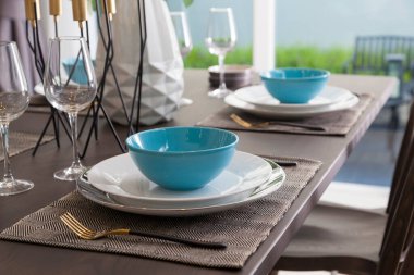 Modern evdeki ahşap masa üzerinde mavi ve beyaz tabak..