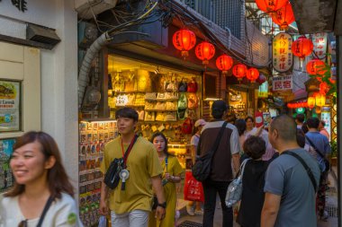 Turist kalabalığı, New Taipei City, Tayvan 'daki Old Town Jiufen' de alışveriş ve sokak yemekleri yemekten keyif alıyor.