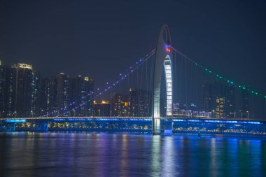 Guangzhou şehir manzarası Pearl Nehri üzerinde yükseliyor ve Liede Köprüsü geceleri Çin 'in Guangzhou şehrinde aydınlanıyor.