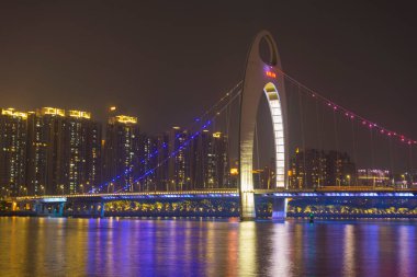 Guangzhou şehir manzarası Pearl Nehri üzerinde yükseliyor ve Liede Köprüsü geceleri Çin 'in Guangzhou şehrinde aydınlanıyor.