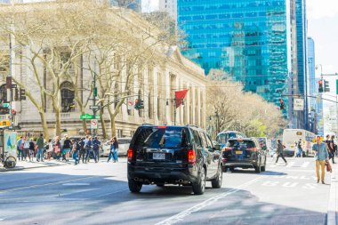 New York City, New York - 26 Nisan 2018: Birçok araba 5. Bulvar 'da New York City, New York' ta 26 Nisan 2018 'de arka planda binayla birlikte gidip geliyor..
