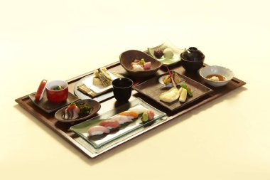 Premium Bento seti - Pastel arka planda suşi, salata ve yemek.