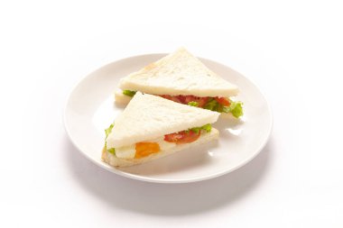 Beyaz tabakta yumurta ve sebzeli leziz sandviç..