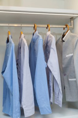 Wardrobe closet with different stylish clothes in modern home.