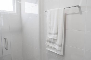 Beyaz havlu beyaz banyoda askıda..