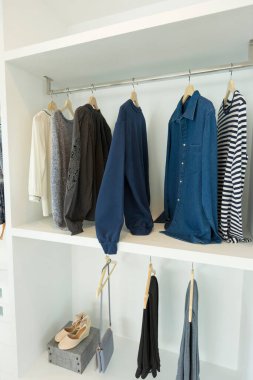 Giysiler evdeki beyaz gardıropta sallanıyor..