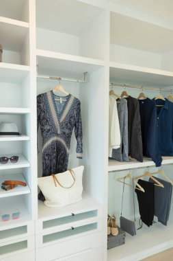 Giysiler evdeki beyaz gardıropta sallanıyor..