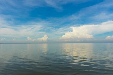 Mavi gökyüzü ve deniz. Mavi gökyüzü ve deniz ufkunda bulutlar okyanusta dalgalı suyla birlikte. 