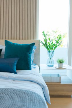 Beyaz, sarı ve mavi yastığın içi rahat, modern yatak odasında..