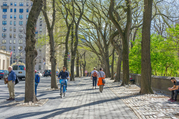 New York, USA - April 26,2018 : People walking on footpath between 5th Ave. and Central Park in New York,USA on April 26,2018.
