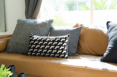 Modern oturma odasının içinde kanepe ve yastıklar var. 