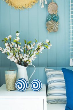 Mavi duvarda asılı hasır şapka