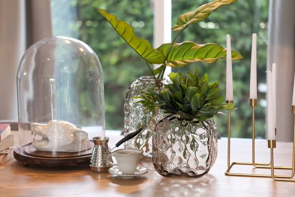テーブルの上に緑の葉を持つガラスの花瓶 — ストック写真